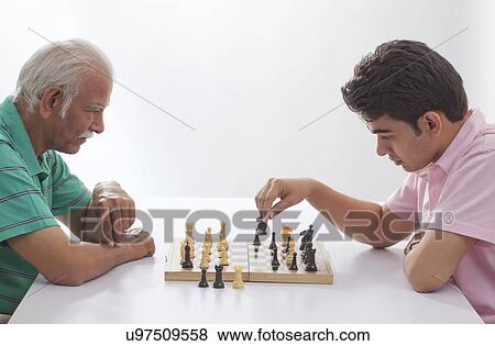 Stock Photo - Grandfather and grandson playing chess. Fotosearch