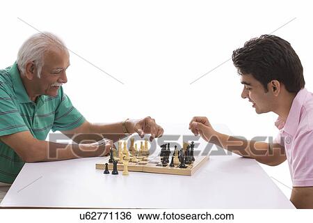 Stock Photograph - Grandfather and grandson playing chess. Fotosearch