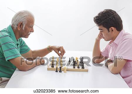 Stock Photography - Grandfather and grandson playing chess. Fotosearch