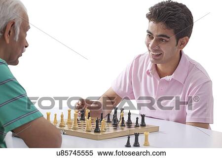 Stock Photography - Grandfather and grandson playing chess. Fotosearch