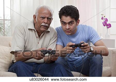 Picture - Grandfather and grandson playing video game. Fotosearch