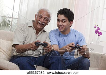 Grandfather and grandson playing video game View Large Photo Image Stock Image - Grandfather and grandson playing video game. Fotosearch