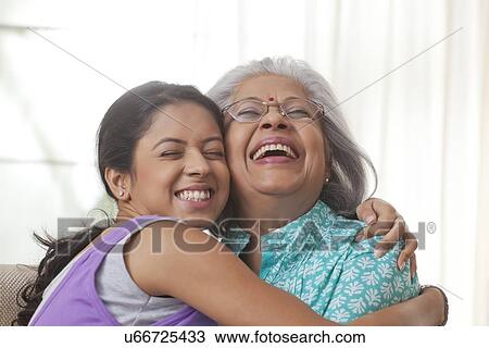 Stock Image - Grandmother and granddaughter hugging each other. Fotosearch