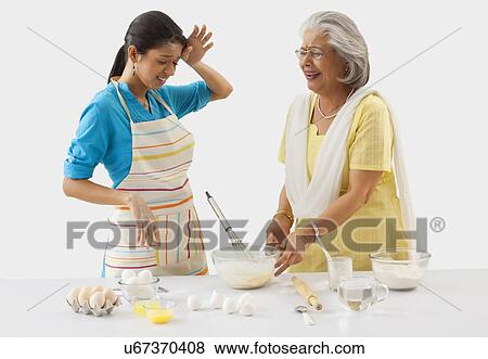 Stock Photo - Grandmother and granddaughter working in the kitchen. Fotosearch