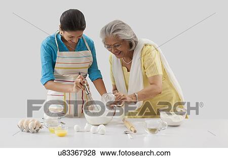 Grandmother and granddaughter working in the kitchen View Large Photo Image Stock Photo - Grandmother and granddaughter working in the kitchen. Fotosearch