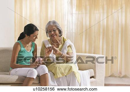 Stock Photograph - Grandmother teaching granddaughter how to knit. Fotosearch