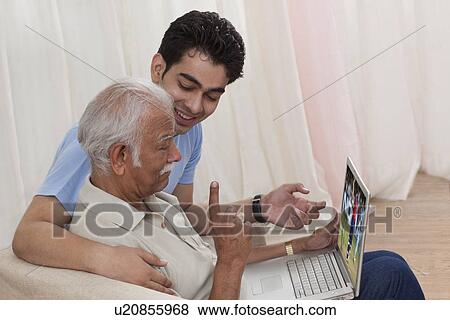 Stock Photo - Grandson and grandfather with a laptop. Fotosearch