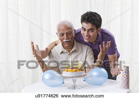 Stock Photograph - Grandson celebrating grandfather's birthday. Fotosearch