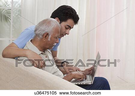 Grandson teaching grandfather how to operate laptop View Large Photo Image Stock Photography - Grandson teaching grandfather how to operate laptop. Fotosearch