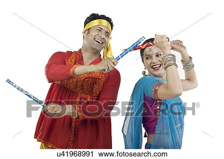 Gujarati couple performing dandiya dance View Large Photo Image Stock Image - Gujarati couple performing dandiya dance . Fotosearch