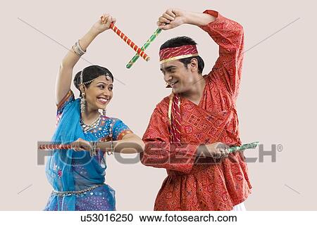 Stock Image - Gujarati couple performing dandiya . Fotosearch