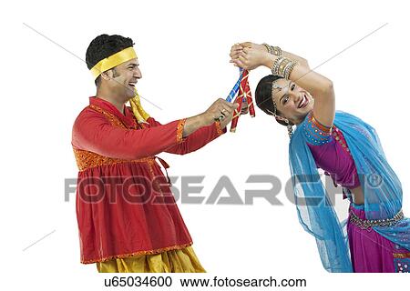 Gujarati couple performing dandiya dance View Large Photo Image Stock Image - Gujarati couple performing dandiya dance . Fotosearch