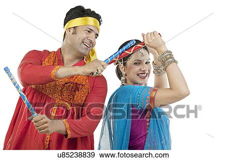 Gujarati couple performing dandiya dance View Large Photo Image Stock Photo - Gujarati couple performing dandiya dance . Fotosearch