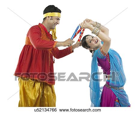Gujarati couple performing dandiya dance View Large Photo Image Stock Photograph - Gujarati couple performing dandiya dance . Fotosearch