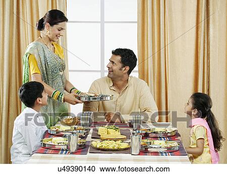 Stock Image - Gujarati family having lunch . Fotosearch