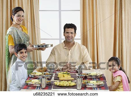 Stock Image - Gujarati family having lunch . Fotosearch