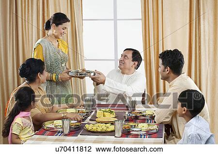 Stock Image - Gujarati family having lunch . Fotosearch