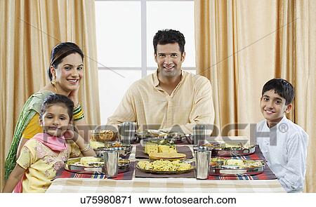 Stock Image - Gujarati family having lunch . Fotosearch