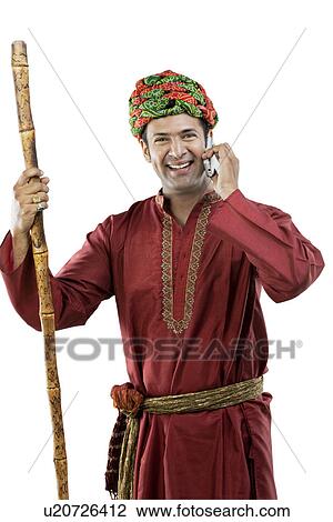 Stock Image - Gujarati man talking on a mobile phone . Fotosearch
