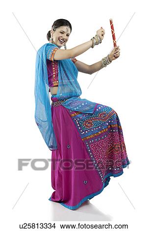 Gujarati woman dancing with dandiya sticks View Large Photo Image Picture - Gujarati woman dancing with dandiya sticks . Fotosearch