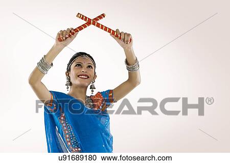 Stock Image - Gujarati woman performing dandiya . Fotosearch