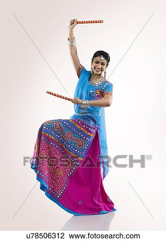 Stock Image - Gujarati woman with dandiya sticks . Fotosearch
