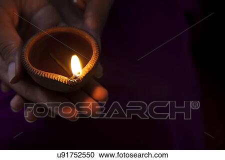 Hand holding a diya View Large Photo Image Stock Image - Hand holding a diya . Fotosearch