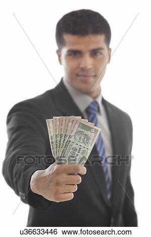 Handsome business man holding Indian currency View Large Photo Image Stock Photograph - Handsome business man holding Indian currency . Fotosearch
