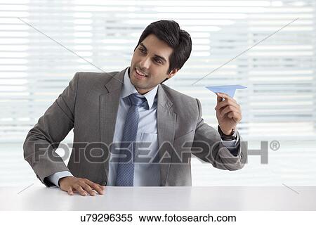 Stock Photography - Handsome businessman playing with paper airplane . Fotosearch