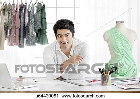 Stock Image - Handsome male fashion designer smiling in studio . Fotosearch