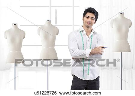 Handsome male fashion designer standing by mannequin at studio View Large Photo Image Stock Photograph - Handsome male fashion designer standing by mannequin at studio . Fotosearch