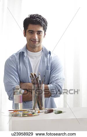 Stock Photo - Handsome male painter with arms crossed in art studio . Fotosearch