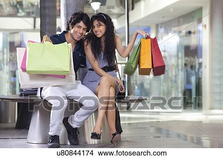 Handsome young couple showing shopping bags at mall View Large Photo Image Picture - Handsome young couple showing shopping bags at mall . Fotosearch