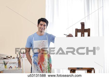 Stock Photo - Handsome young man in painting studio . Fotosearch
