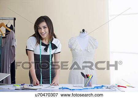 Happy beautiful fashion designer working in studio View Large Photo Image Stock Photo - Happy beautiful fashion designer working in studio . Fotosearch