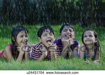 Happy boys and girls catching raindrops on tongue View Large Photo Image Picture - Happy boys and girls catching raindrops on tongue . Fotosearch