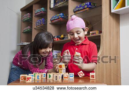 Happy brother and sister playing with wooden toy blocks View Large Photo Image Stock Photo - Happy brother and sister playing with wooden toy blocks . Fotosearch