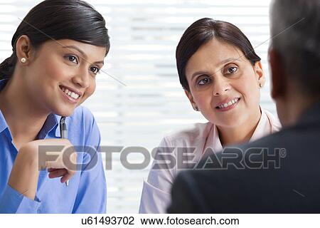 Stock Image - Happy business team discussing together in office . Fotosearch