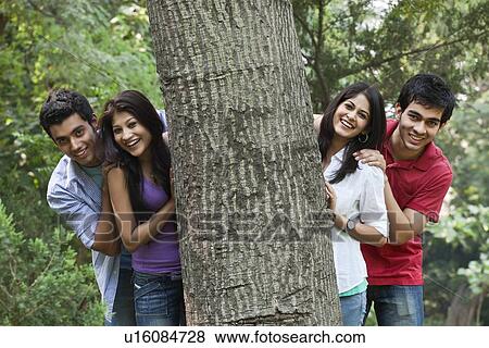 Happy college students behind tree View Large Photo Image Stock Photo - Happy college students behind tree . Fotosearch