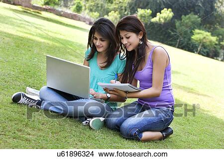 Happy college students taking notes from laptop View Large Photo Image Picture - Happy college students taking notes from laptop . Fotosearch