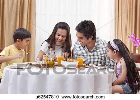 Happy family eating pizza together at restaurant View Large Photo Image Stock Image - Happy family eating pizza together at restaurant . Fotosearch