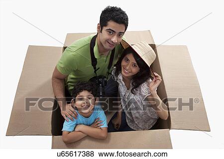 Happy family on vacation smiling inside cardboard box View Large Photo Image Stock Photo - Happy family on vacation smiling inside cardboard box . Fotosearch
