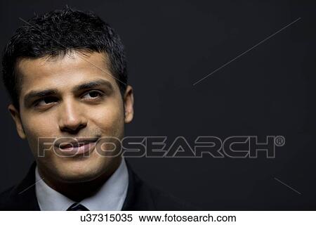 Stock Photography - Happy male executive contemplating over black background . Fotosearch