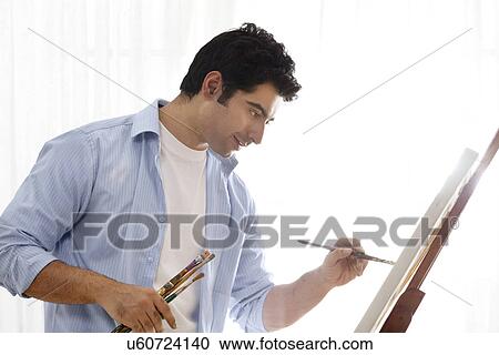 Happy male painter painting in art studio View Large Photo Image Stock Image - Happy male painter painting in art studio . Fotosearch