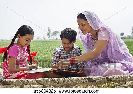 Stock Photography - Happy mother guiding children with their homework . Fotosearch