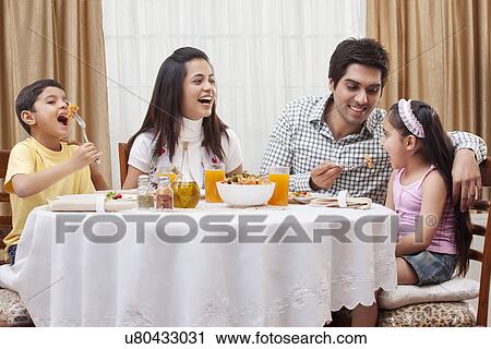 Happy parents and children eating pizza together at restaurant View Large Photo Image Stock Image - Happy parents and children eating pizza together at restaurant . Fotosearch