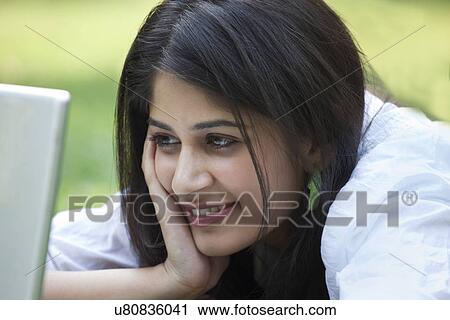 Stock Image - Happy woman using laptop on campus . Fotosearch