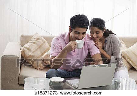 Happy young couple browsing together at home View Large Photo Image Stock Image - Happy young couple browsing together at home . Fotosearch