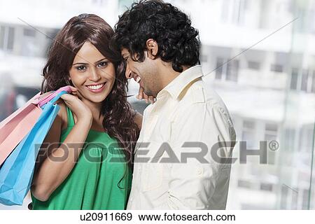 Stock Photo - Happy young couple having great time while shopping . Fotosearch