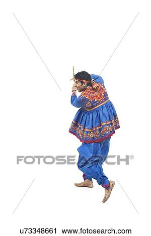 Stock Image - Happy young man in kedia and dhoti performing Dandiya Raas over white background. Fotosearch